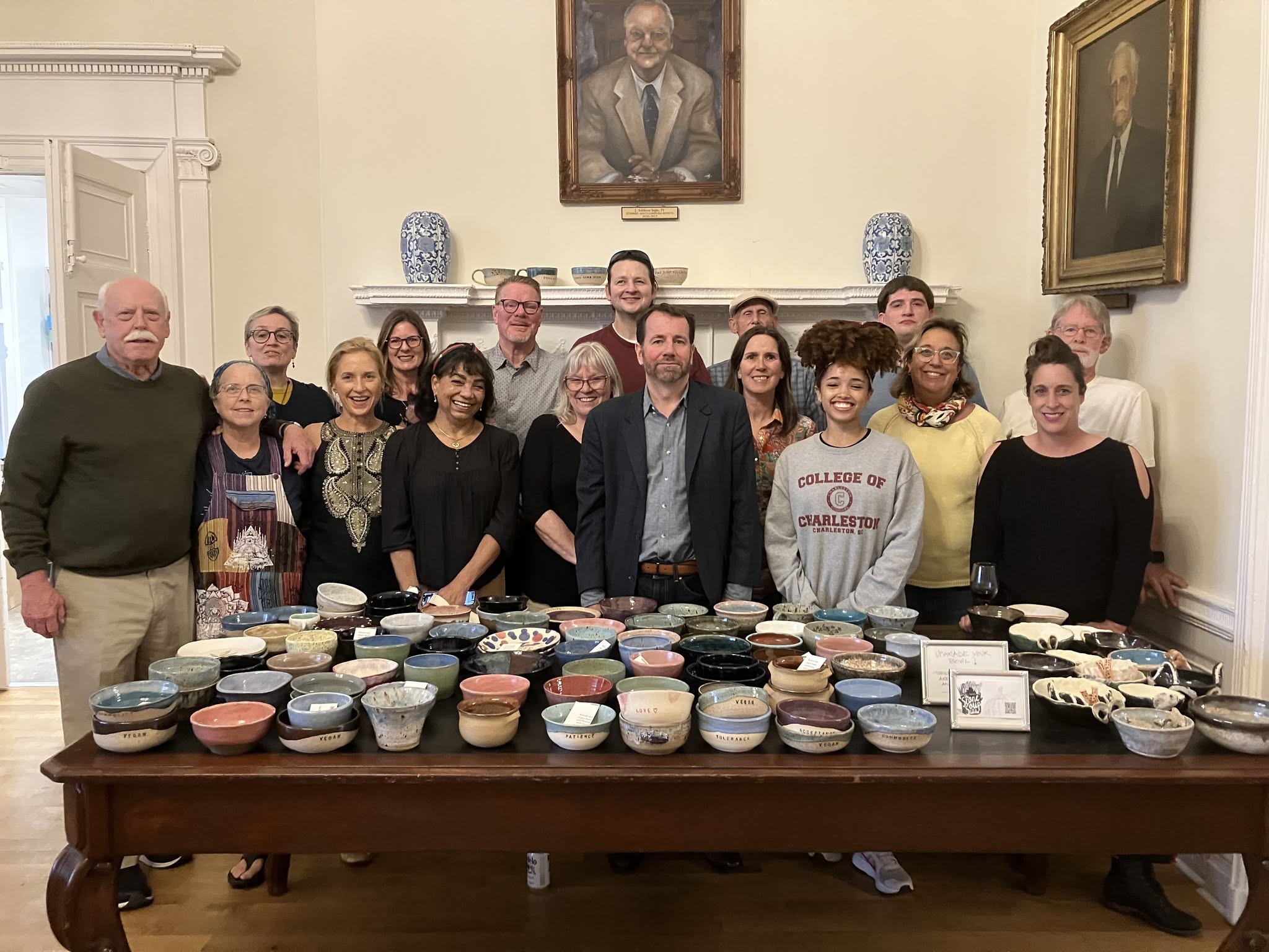 Stone Soup Collective supporters gathered behind a table of handmade bowls